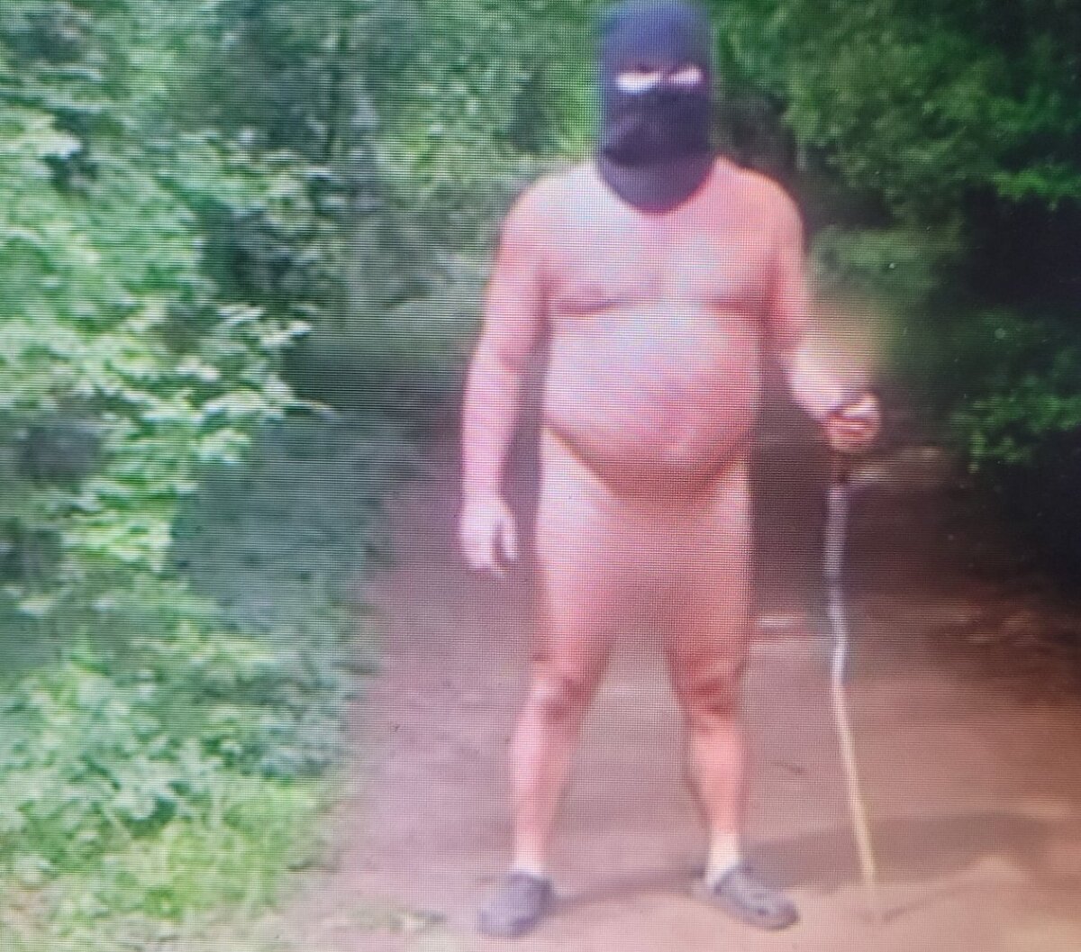 Nahy muz v kukle beha po lese blizko zrucaniny hradu